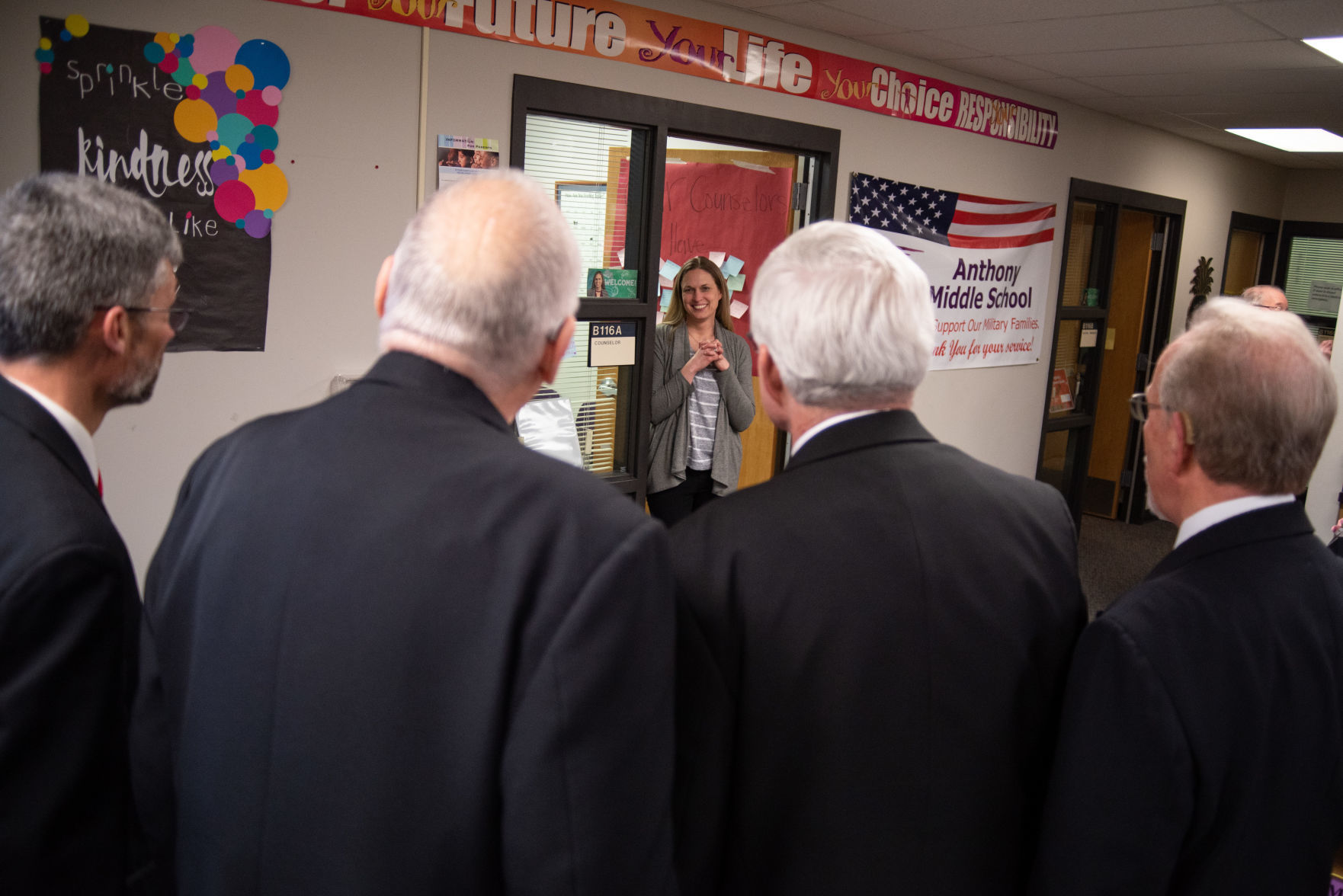 Shelly Ingram, a counselor at Susan B. Anthony Middle School, listens to The Charades deliver her Singing Valentine on Thursday.